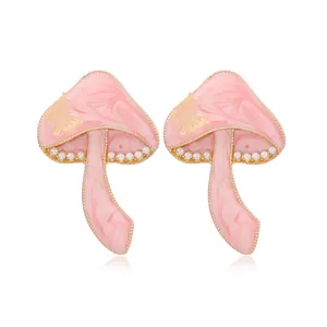 Pendientes de hongo rosa con patrón de mariposa dorada y detalles de perlas blancas