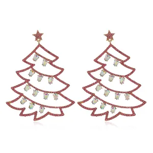 Dettaglio di orecchini a forma di albero di Natale dorati con cristalli rosa e cangianti