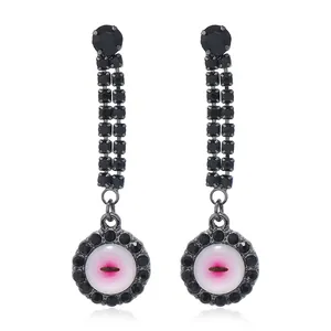 Macro detail of gothic evil eye earrings with black rhinestones and pink gradient center