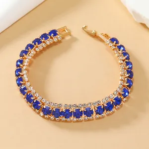 Detail van luxe vergulde armband met koningsblauwe kristallen en fijne diamanten zetwerk