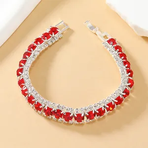 Detail van rode kristallen armband met zilveren legering en vouwsluiting