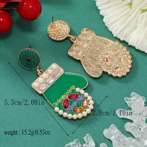 Dettaglio degli orecchini a guanto di Natale con smalto verde e perle, misura 5,3x2,8 cm