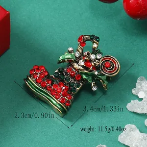 Détail macro d'une broche botte de Noël avec strass et émail sur fond vert festif