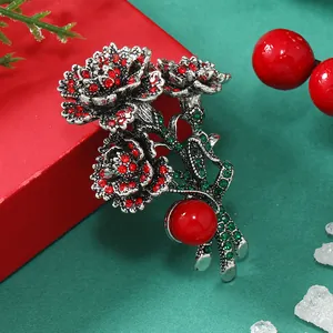 Détail macro d'une broche œillet vintage en argent avec strass rouges et une perle
