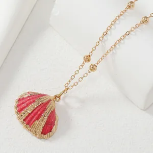 Collier avec pendentif coquillage rouge foncé et détails dorés sur une chaîne satellite