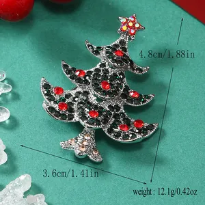 Dettaglio di una spilla a forma di albero di Natale con strass verdi e rossi