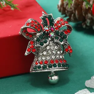 Dettaglio macro della spilla a campana di Natale retrò con strass rossi e verdi