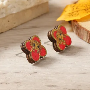 Detailed view of traditional wooden drop earrings with red and gold floral patterns