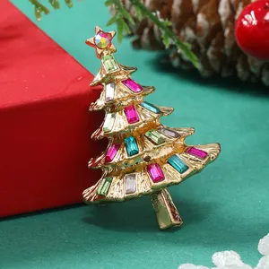 Dettaglio spilla ad albero di Natale dorata con strass colorati e una stella