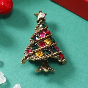 Dettaglio di una spilla vintage ad albero di Natale con strass colorati e stella d'oro
