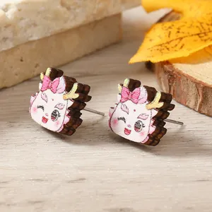 Detailed view of wood dragon stud earrings featuring cute cartoon prints and metal posts