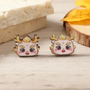 Detail of cute dragon earrings with matte finish on natural wood texture background
