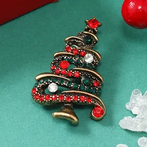 Dettaglio macro della spilla albero di Natale con strass rossi e verdi su base dorata vintage