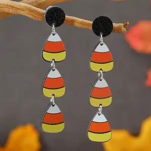 Orecchini di Halloween a tre strati candy corn su un ramo autunnale rustico