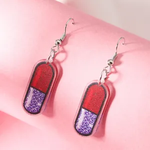 Creative pink acrylic pill capsule earrings with purple glitter detail for girls