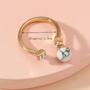 Adjustable gold plated open ring with marble effect bead and cubic zirconia inlay