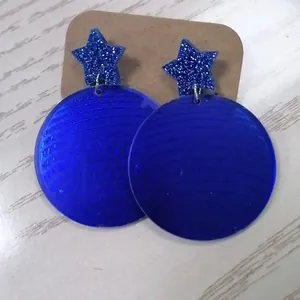 Sparkly blue acrylic geometric star and circular drop earrings on a craft card