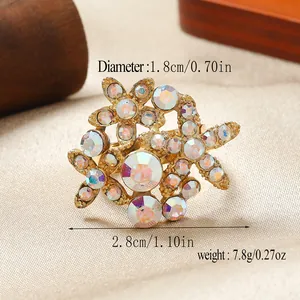 Dettaglio macro di un anello a fiore dorato con strass che mostra dimensioni e peso