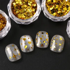 Detail of gold star and heart sequins for nail art applied on silver glitter base