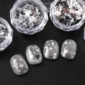 Detailed view of silver star heart and dot nail art sequins on mannequin nails