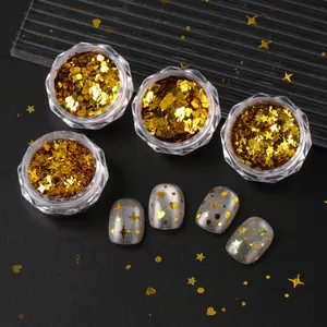 Macro view of gold heart and star nail sequins on dark background with application effect