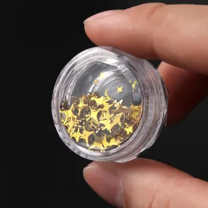 Macro shot of gold four-pointed star sequins for nail art in a clear plastic container