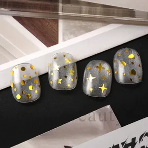 Detail of silver cat-eye press-on nails with gold star, heart, and dot sequins