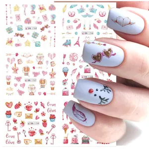Detailed view of watercolor heart and balloon nail stickers applied on manicured nails