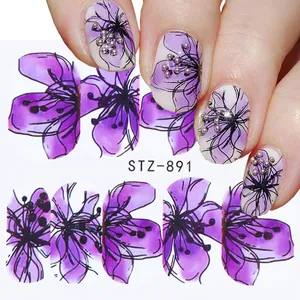 Dettaglio di adesivi per unghie con fiori viola applicati su unghie naturali.