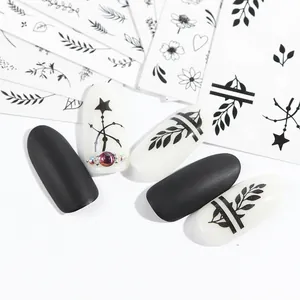 Detailed macro view of black floral nail art stickers and star pendant nail decals