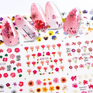 Macro shot of colorful floral water slide nail decals on pink translucent false nails