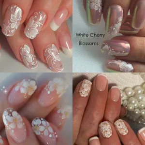 Detail view of 3D white cherry blossom nail art stickers with relief and pearl accents