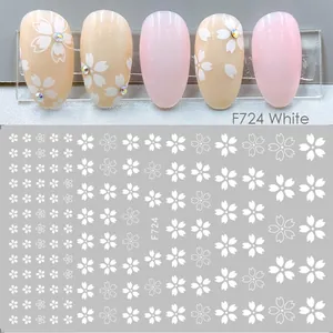 Detail showing white cherry blossom 3D nail stickers on pink manicure and sheet F724