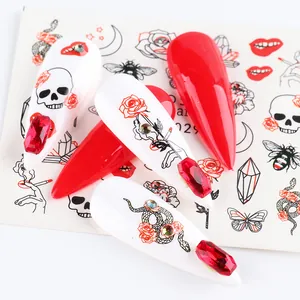 Macro detail of red and white gothic nail stickers with skull, rose, and rhinestone motifs