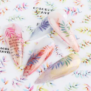 Macro detail of watercolor leaf nail stickers with subtle gold shimmer and translucent finish