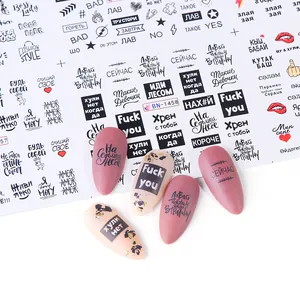 Detail of Russian style nail stickers with red lips and text on pink false nails