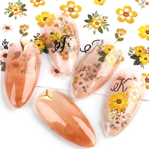 Macro detail of floral nail art stickers on almond press-on nails with golden accents