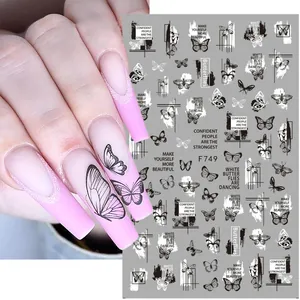 Detail of 3D nail art stickers featuring black butterfly patterns and quote stickers