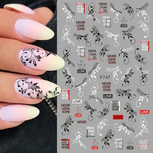 Detail of 3D nail art stickers with black and white vines and inspirational text