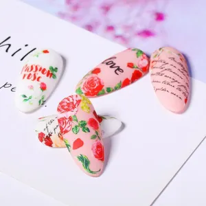 Dettaglio macro di adesivi per unghie con rose rosse e motivi decorativi vintage