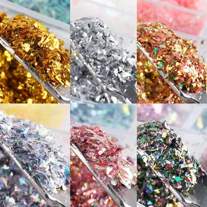 Detailopname van holografische goud- en zilveren nagelkunstvlokken met metaalglitters