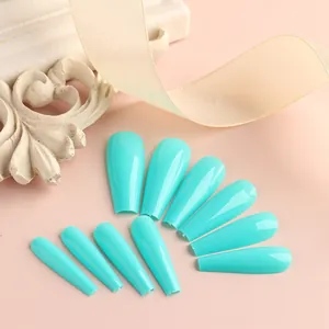 Unghie finte a ballerina color turchese lucido con nastri decorativi in seta bianchi