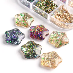Nahaufnahme von glitzernden Stern-Nagelcharms aus Harz und transparenter 6-Gitter-Box