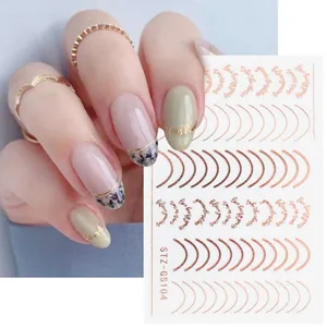 Dettaglio di adesivi per unghie oro stile francese con curve metalliche e scritte