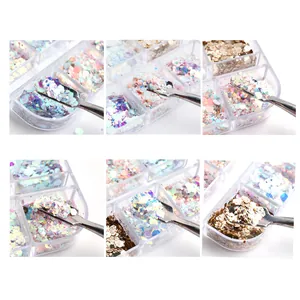Detail of holographic nail glitter sequins in assorted shapes and colors with a scoop tool