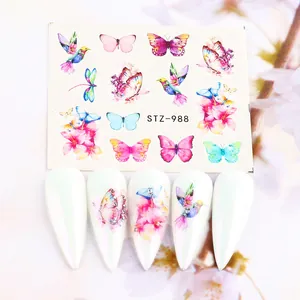 Dettaglio di adesivi per unghie con fiori e farfalle su unghie bianche lunghe