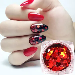 Macro shot of red laser holographic heart nail sequins in a square clear plastic box
