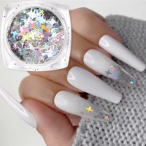 Macro detail of holographic star nail sequins applied on white gradient manicure
