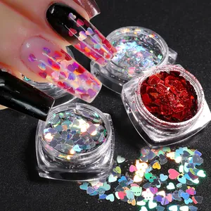 Detailed view of heart-shaped laser nail glitters in jars showing holographic effects