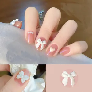 Dettaglio macro di fiocchi bianchi opachi 3D e perle per una manicure elegante